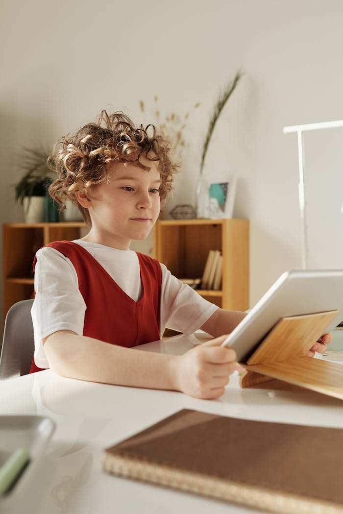 Young child engaged with a tablet for online education at home, promoting digital learning.